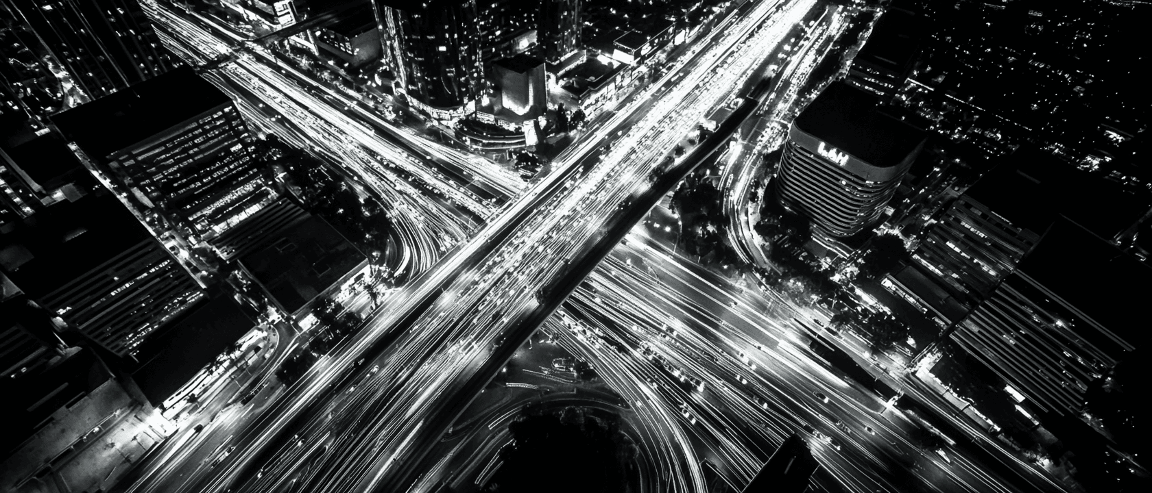 Aerial view of a modern city at night with geometric road patterns